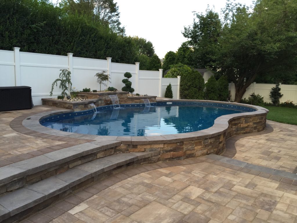 semi in-ground pool with brick landscaping